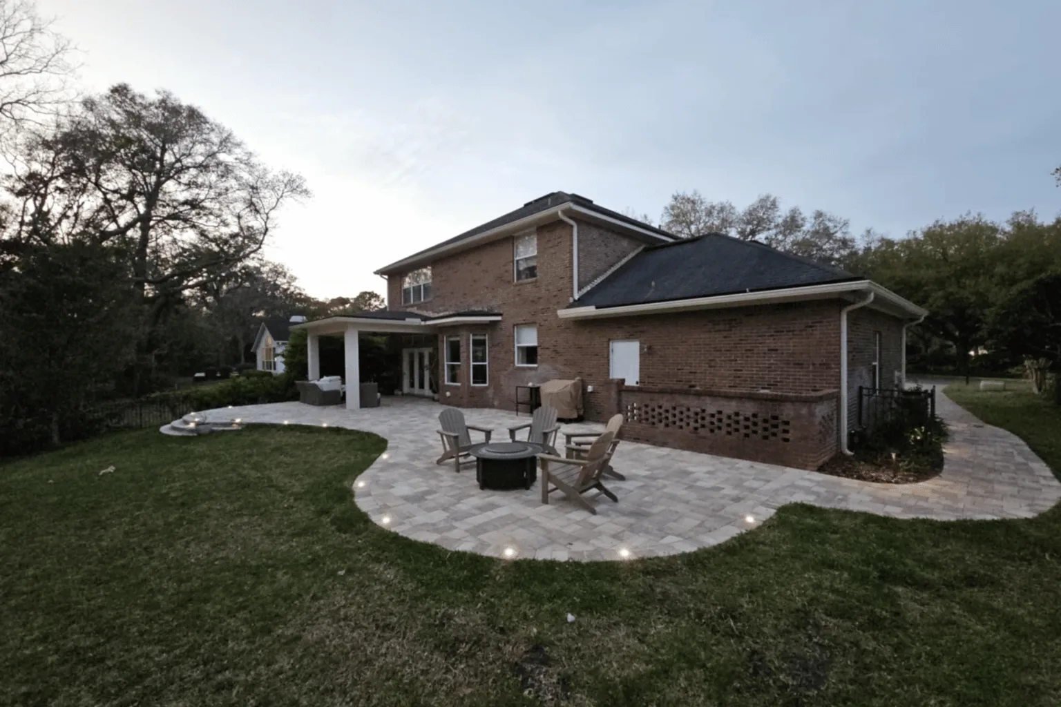 Freeform paver patio installation with fire pit and in-ground lighting by Jax Pavers in Jacksonville FL