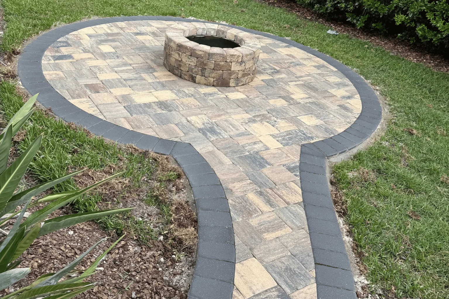 Paver fire pit pad and walkway installation with charcoal border by Jax Pavers in Jacksonville FL