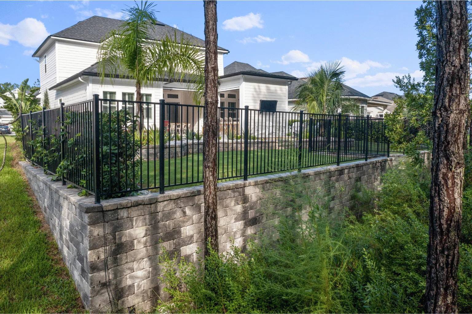 Block retaining wall and iron fence installation by Jax Pavers in Jacksonville FL