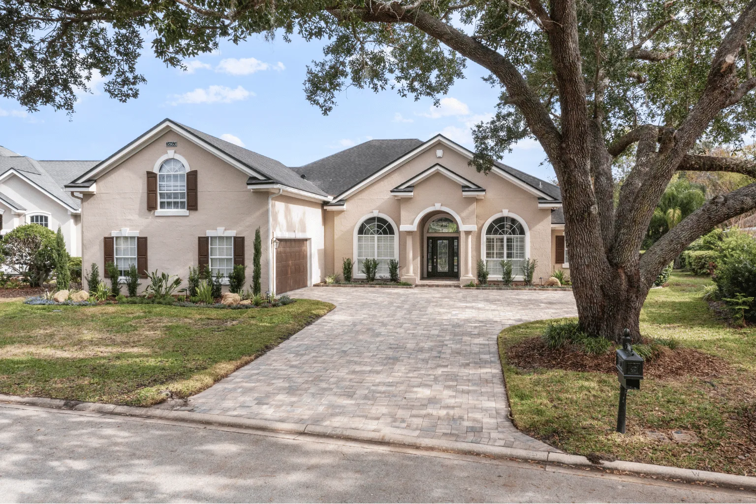 Paver driveway installation at a Jacksonville FL home with mature oak tree by Jax Pavers